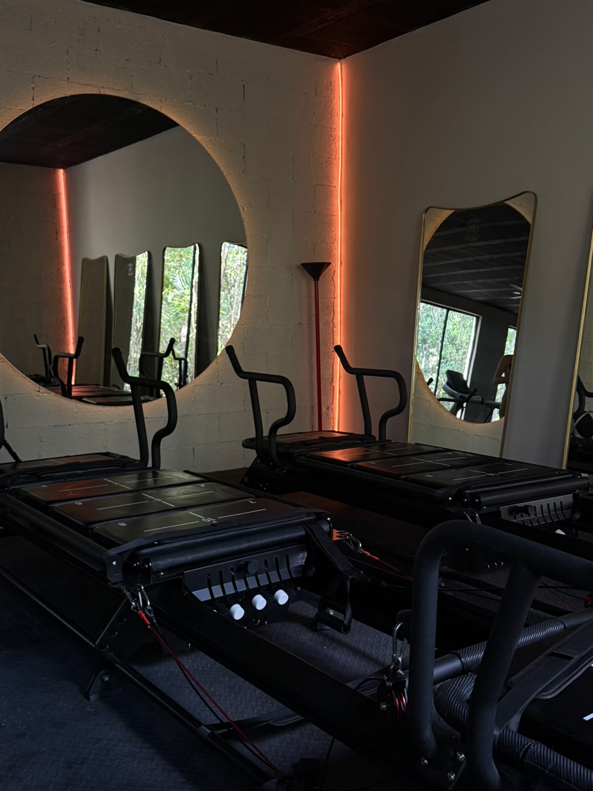 Máquinas de Lagree en la sala de Tempo Movement con espejos circulares retroiluminados